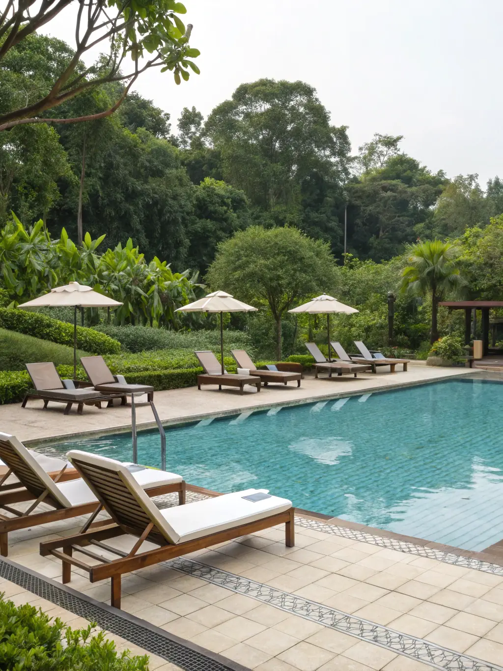 A sparkling clean swimming pool with crystal clear water, highlighting LHS's pool care service. The image should evoke feelings of relaxation and enjoyment.